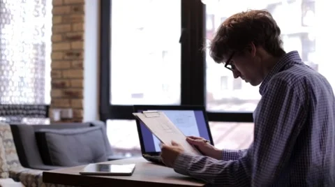 Man Checks Drawings Using a Laptop Video stock 63863198