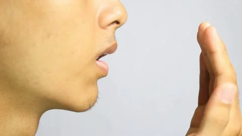 A man checks his breath Stock Footage 295944503