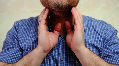 A man checks his lymph nodes. An unrecognizable man with a beard is experienc Stock Footage 170389385