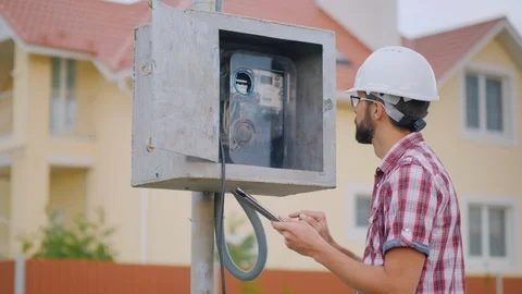 A man checks the meter reading electricity in the cottage Stock Footage 93043884