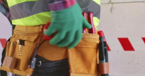 Man checks performance of measuring tape standing against wall Stock Footage 309928875