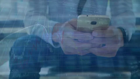 Man checks phone in front of fluctuating stock market display with electric Stock Footage 330724888