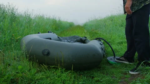 A man checks the pumping level of the boat before fishing in the lake Stock Footage 237362062