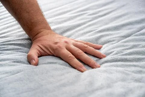The man checks the quality and softness of the new mattress he will buy by .. 스톡 사진