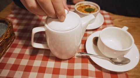 Man checks the readiness of tea brewing on eye by lifting the lid of the kettle. Stock Footage 99881875