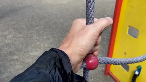 Man checks the reliability of a child's rope net Video stock 160032175