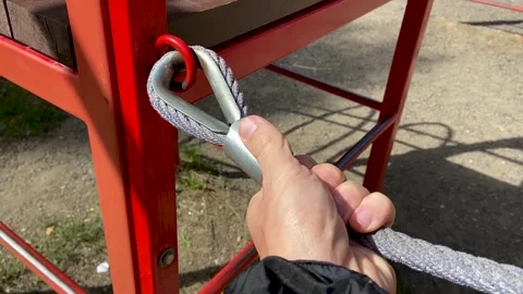 Man checks the reliability of a child's rope net Stock Footage 166314157