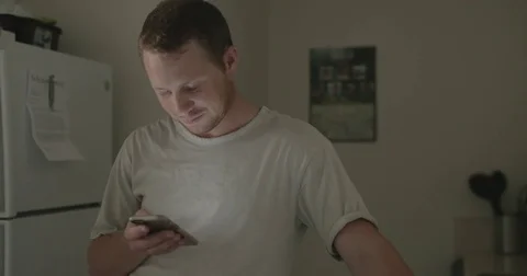 Man checks smartphone in kitchen Stock Footage 78038200