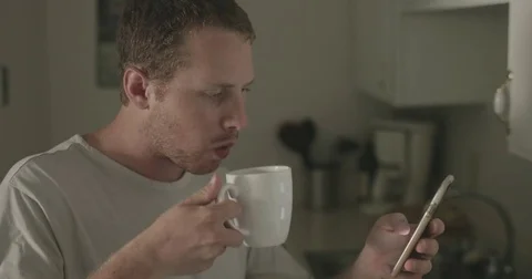 Man checks smartphone in kitchen Stock Footage 78038356