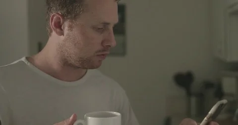 Man checks smartphone in kitchen Stock Footage 78038372