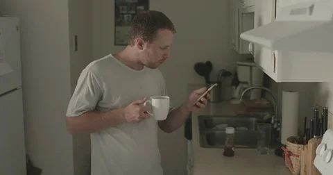 Man checks smartphone in kitchen Stock Footage 78038416