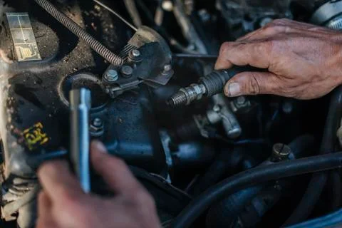 Man checks the spark plug on the old car Foto stock