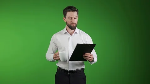 A man checks stats on the board. With a mug in his hand. Shows happiness. Smiles Stock-Footage 114577955