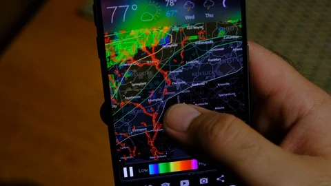 Man checks storm warning on smartphone 스톡 동영상 108760119