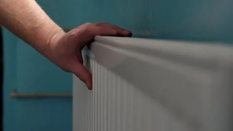  man checks temperature of radiator battery of the heating system with his hand. Stock Footage 221349110