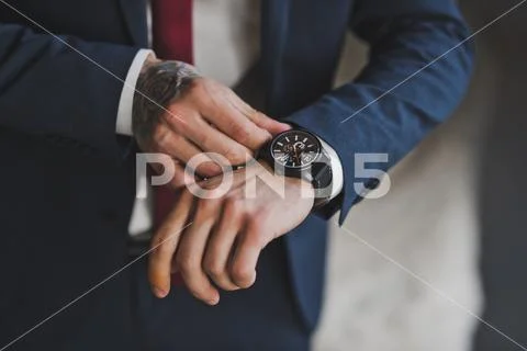 The man checks the time on the wristwatch 1584. Stock Photos