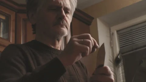 Man checks the tip of a knife close-up video Stock Footage 85799949