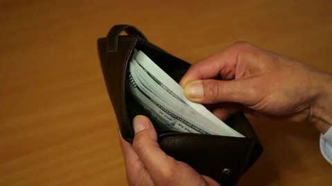 Man checks wallet containing large amount of cash funds. Stock Footage 336623946