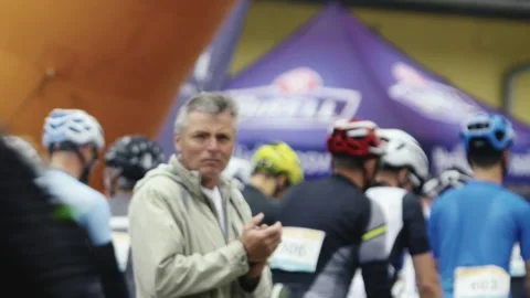 A man cheers on the cyclists surrounding him during the start of the race Stock Footage 245277687