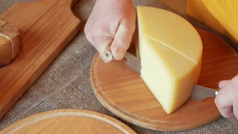 Man cheesemaker cuts cheese, a thin slice, a special knife. Beautiful footage Stock Footage 164668767