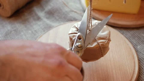 Man cheesemaker wraps cheese in craft paper, packs for sale, buyer. Gift Stock Footage 164668438