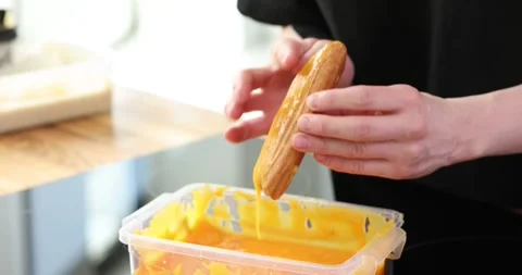 Man chef dips eclair in condensed milk d... | Stock Video | Pond5