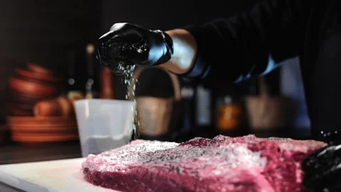 Man chef hand sprinkling salt dry seasonings to farm meat piece at rustic Video stock 255740720