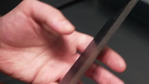 Man chef hand touches a blade of sharp cooking knife Stock Footage 203590639
