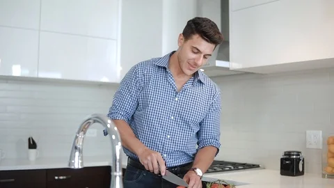 Man chef in kitchen cutting vegetables and stirring pot for healthy recipe Stock Footage 100574416