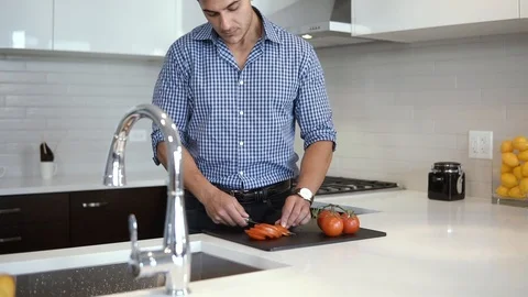 Man chef in kitchen cutting vegetables and stirring pot for healthy recipe Stock Footage 100574466