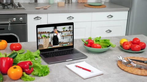 Man chef in laptop computer screen tells removes vegetables from paper bag Stock Footage 156225951
