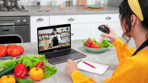 Man chef in laptop computer screen tells removes vegetables from paper bag Stock Footage 160059071