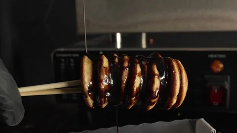 Man chef put chocolate syrup on delicious mini pancakes in the box Stock Footage 321055156