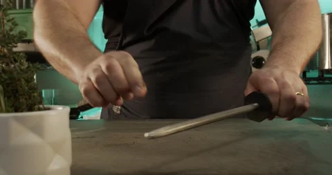 Man Chef Sharpening Knife Over Cutting Board Cinematic Front Shot 4K 23.98 fps Stock Footage 149622388
