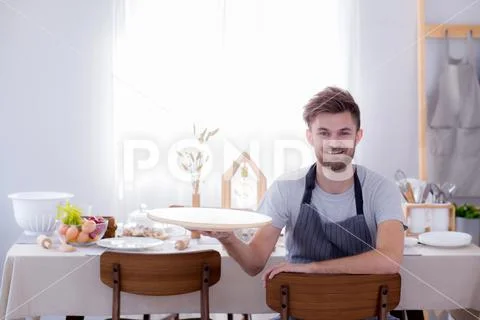 Man chef smiling looking camera with holding tray empty kitchen background Stock Photos