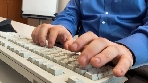 A man with chewed fingernails types on a German keyboard Stock Footage 123441179