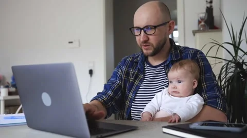 Man with a child in his hands tries to work from home. Stock Footage 280306376