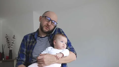Man with a child in his hands tries to work from home. Stock Footage 280306437