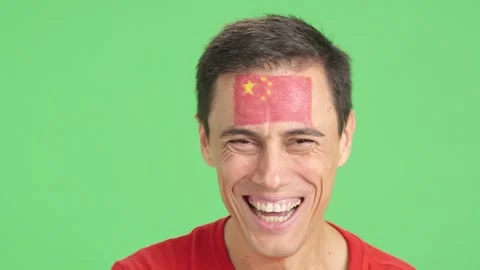 Man with a chinese flag painted on the face smiling Stock Footage 264994027