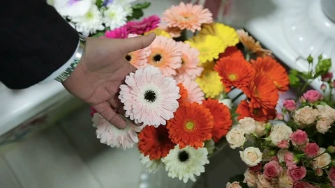 Man choose a flower type for flowers bouquet for his wife at flower shop Stockbeeldmateriaal 102368684