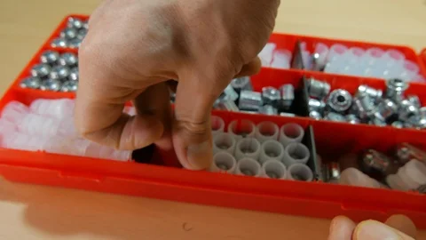 A man chooses a 20-caliber bullet to equip a hunting cartridge. Stock Footage 123089908