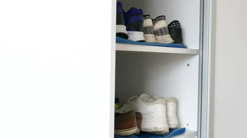 The man chooses and pulls the shoes out of the closet Stock Footage 135809018
