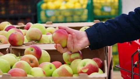 A man chooses apples in a store. Stock Footage 228633258