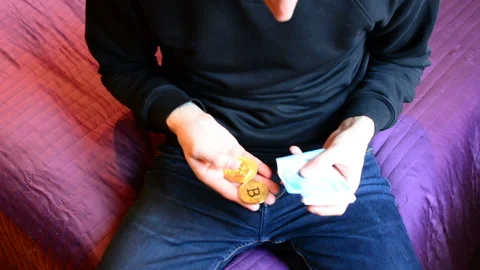 A man chooses between bitcoin and cash ruble Stock Footage 89409120
