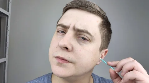 Man chooses between a plastic and a wooden ear stick. The concept of protecting  Stock Footage 126407120