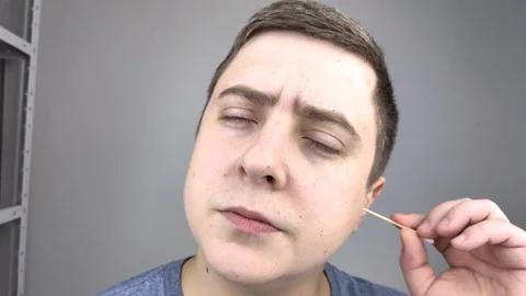 Man chooses between a plastic and a wooden ear stick. The concept of protecting  Stock Footage 126407136