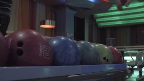 Man chooses bowling ball rolling to alley HD video. Guy doing throw Stock Footage 72219556