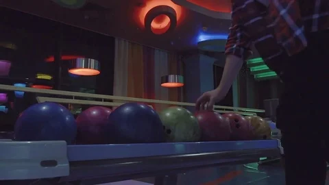 Man chooses bowling ball rolling to alley HD leisure video. Guy doing throw Stock Footage 72219557