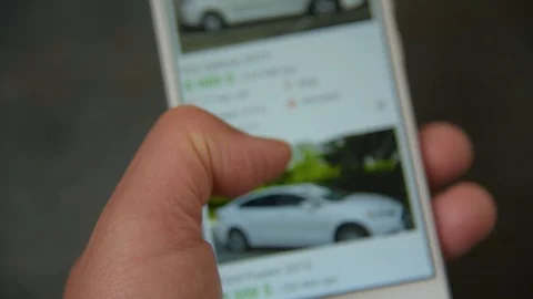 Man chooses car in smartphone Stock Footage 107715736