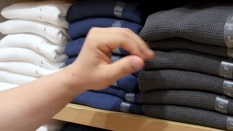 Man chooses clothes on shelves in the store close-up. Stock-Footage 339439242